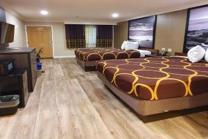 A bed or beds in a room at Super 8 by Wyndham Cypress Buena Park Area