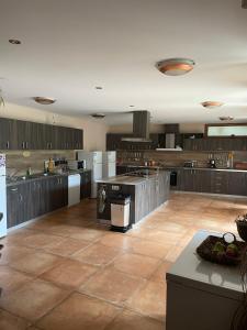 a large kitchen with wooden cabinets and a tile floor at Eco House Kitana in Tschenge