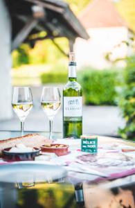 uma garrafa de vinho sentada numa mesa com dois copos em Les géodes du Domaine Jean Got, proche de Saint Emilion em Lugaignac