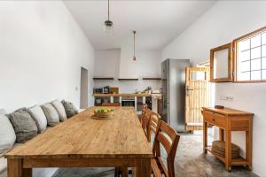 a kitchen and dining room with a wooden table at CAN FERRER Authentic payesa house in San Antonio