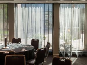 a conference room with a table and chairs and large windows at Quay West Suites Melbourne in Melbourne