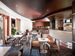 a restaurant with tables and chairs and a bar at Quay West Suites Melbourne in Melbourne
