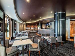 a restaurant with tables and chairs and a barrel at Quay West Suites Melbourne in Melbourne