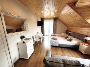 Habitación grande con 2 camas y mesa. en Willa Beskidzka en Myślenice