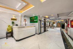 a man standing at a counter in a hotel lobby at Nhan Hoa Hotel in Hanoi