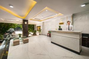 a man standing behind a counter in a restaurant at Nhan Hoa Hotel in Hanoi