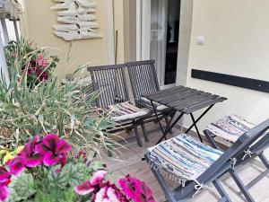 two chairs and a table on a porch with flowers at Ferienwohnung Munich in Traben-Trarbach
