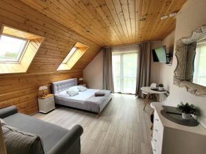 a bedroom with a bed in a room with wooden ceilings at Willa Beskidzka in Myślenice