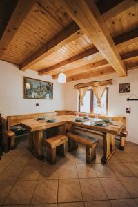 jadalnia z drewnianymi stołami i ławkami w pokoju w obiekcie Cabana La Tiby w mieście Porumbacu de Sus