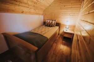 mały pokój z łóżkiem w drewnianym domku w obiekcie Cabana La Tiby w mieście Porumbacu de Sus