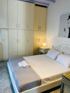 a bedroom with a large bed with white cabinets at Aphrodite sunshine suite in Mikonos