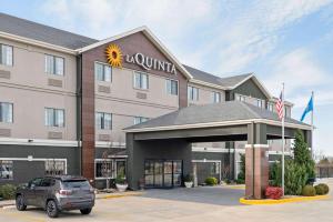 a hotel with a suv parked in a parking lot at La Quinta by Wyndham Ada in Ada