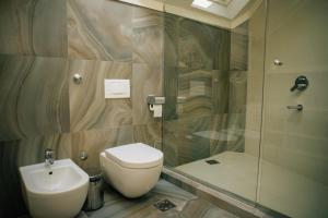 y baño con aseo, lavabo y ducha. en Filip Deluxe Rooms, en Kotor