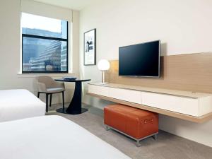 a hotel room with a desk with a television on a wall at Hyatt Centric The Loop Chicago in Chicago
