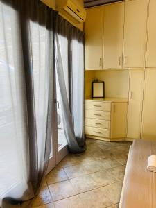 a room with a window with curtains and a table at Aphrodite sunshine suite in Mýkonos City