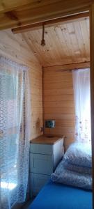 a bedroom with a bed and a window with curtains at Leśny zakątek malediwy Jacuzzi free in Jaworzno