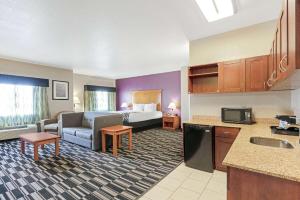 a hotel room with a kitchen and a living room at La Quinta by Wyndham Ada in Ada