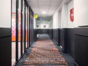 a hallway with a carpet on the floor at ibis Styles Carcassonne La Cité in Carcassonne