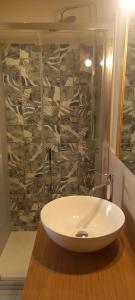 een witte wastafel in een badkamer met een muur bij La Pifote in Villes-sur-Auzon