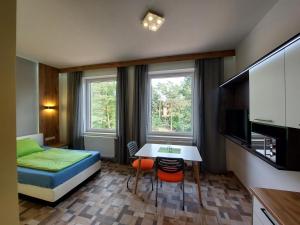a small room with a bed and a table and a bedroom at Wesendorf Residenz Premium Lounge in Wesendorf