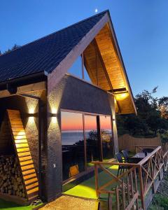 een huis met een terras met een tafel en stoelen bij Lavinya Suit Bungalov in Rize