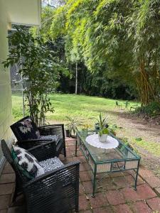 a patio with two chairs and a glass table at Bamboo Cabin in Kuranda