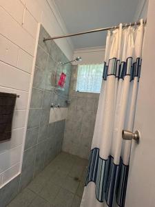 a shower with a shower curtain in a bathroom at Bamboo Cabin in Kuranda