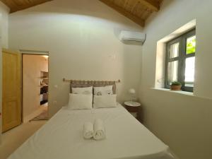 a bedroom with a bed with white shoes on it at Kilada Holiday Home in Koilás