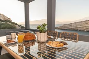 Georgia Apartment في ماتالا: طاولة مع طعام ومشروبات على شرفة