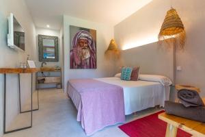 a bedroom with a bed and a painting on the wall at Boho Suites Denia in Denia +42 photos
