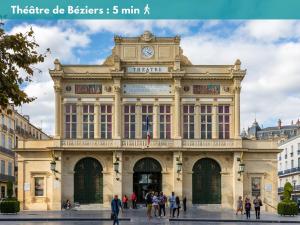 een groot gebouw met daarop een klok bij Élégant Studio Climatisé 'Alma 2' - Cœur de Beziers - Wifi Fibre - Netflix in Béziers