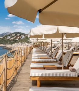 a row of lounge chairs and umbrellas on a pier at Novva Hotels Kas in Kas