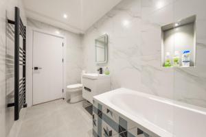 bagno bianco con lavandino e servizi igienici di 6 - West London Brand New Loft a Londra