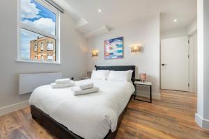 una camera da letto con un grande letto bianco e una finestra di 6 - West London Brand New Loft a Londra