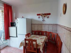 een keuken met een tafel en stoelen en een koelkast bij Krisztina apartman in Balatonfüred