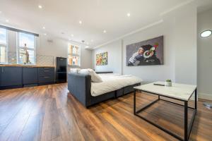 un soggiorno con letto e tavolo di 6 - West London Brand New Loft a Londra
