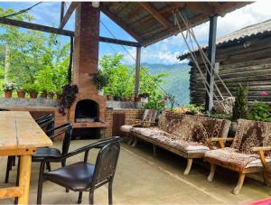 un patio con mesa, sillas y chimenea en Agro Guest House Tsiskari in Machakhela en Khelvach'auri