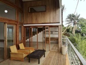 une maison dotée d'une terrasse en bois avec un banc et des chaises dans l'établissement Shabu house, à SantʼAna