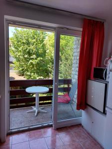 een kamer met een glazen schuifdeur en een tafel bij Krisztina apartman in Balatonfüred