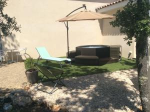 a patio with a chair and an umbrella at Au Petit Bueix in Sillans-la Cascade +47 photos
