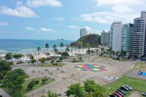een park voor het strand en de oceaan bij joia da enseada, com serviços de praia, de frente para o mar, 3 quartos, TV smart, piscina, academia, salão jogos, brinquedoteca, estacionamento in Guarujá