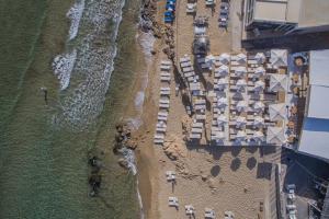 een uitzicht over een strand met gebouwen en de oceaan bij Parthenis Beach, Suites by the Sea in Malia