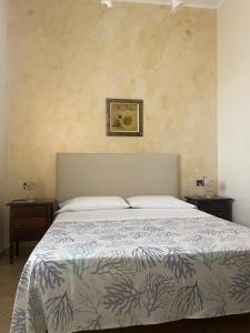łóżko w sypialni z dwoma stolikami nocnymi i dwoma stołami w obiekcie La casa di Giovanna w mieście Lampedusa