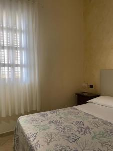 sypialnia z łóżkiem i oknem w obiekcie La casa di Giovanna w mieście Lampedusa