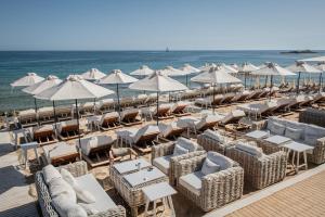 a bunch of chairs and umbrellas on a beach at Parthenis Beach, Suites by the Sea in Malia