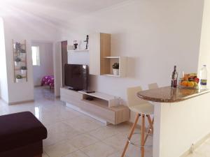 a kitchen and living room with a tv and a counter at Tropicalife in Playa del Ingles +3 photos