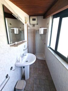 ein Bad mit einem Waschbecken und einer Dusche in der Unterkunft Villa Anita Apartments in Capo dʼOrlando