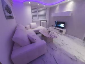 a white living room with a couch and a table at Apartman brdo in Belgrade