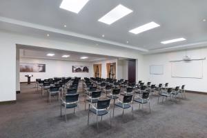 a room with rows of chairs and a white wall at Protea Hotel by Marriott Livingstone in Livingstone