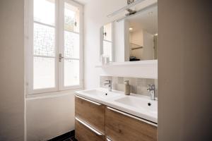 uma casa de banho com um lavatório, um espelho e uma janela em Les géodes du Domaine Jean Got, proche de Saint Emilion em Lugaignac